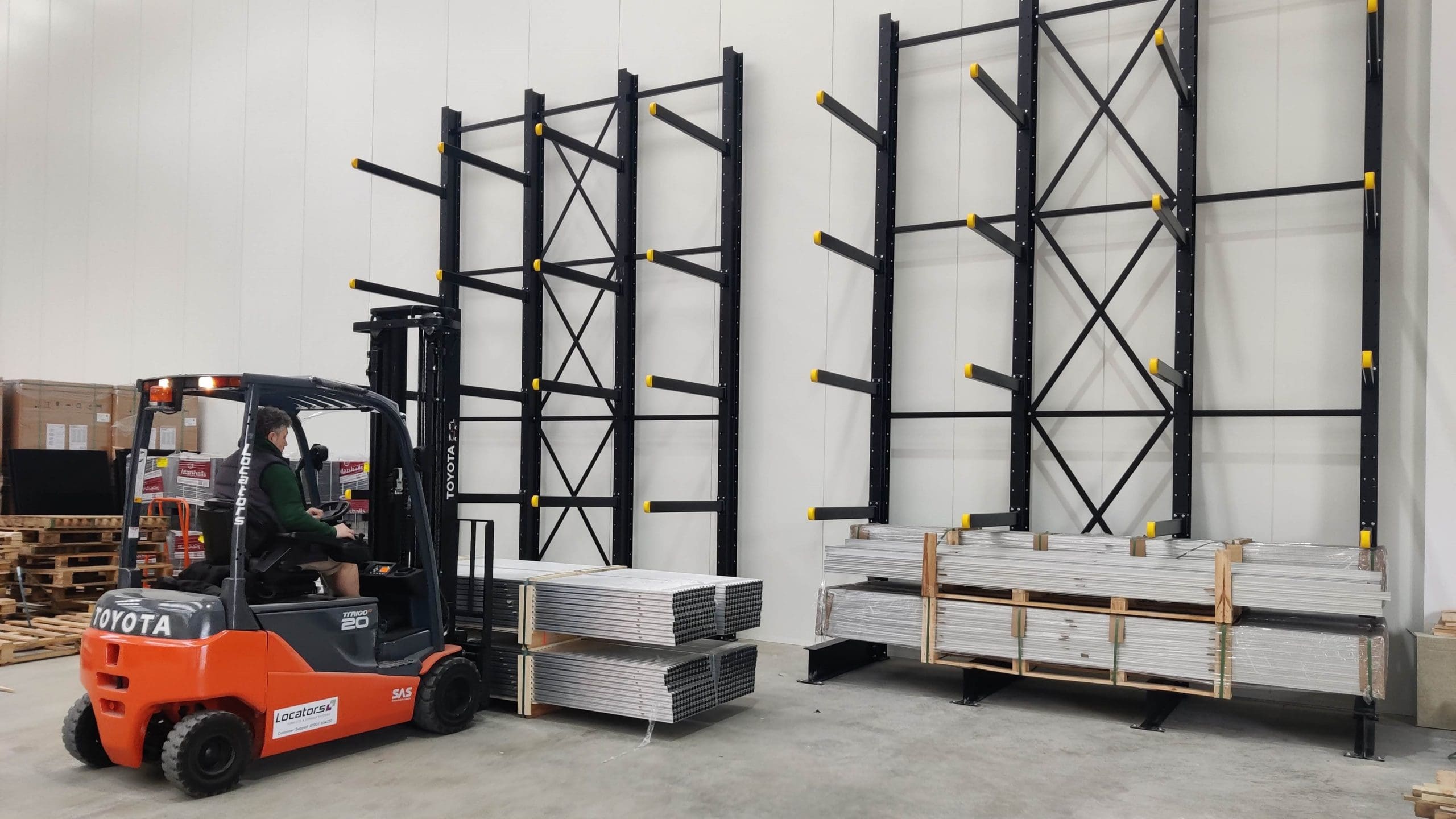 Refurbished Toyota forklift supplied by Locators, in use at HDM Solar's facility, alongside newly installed cantilever racking for efficient material storage.