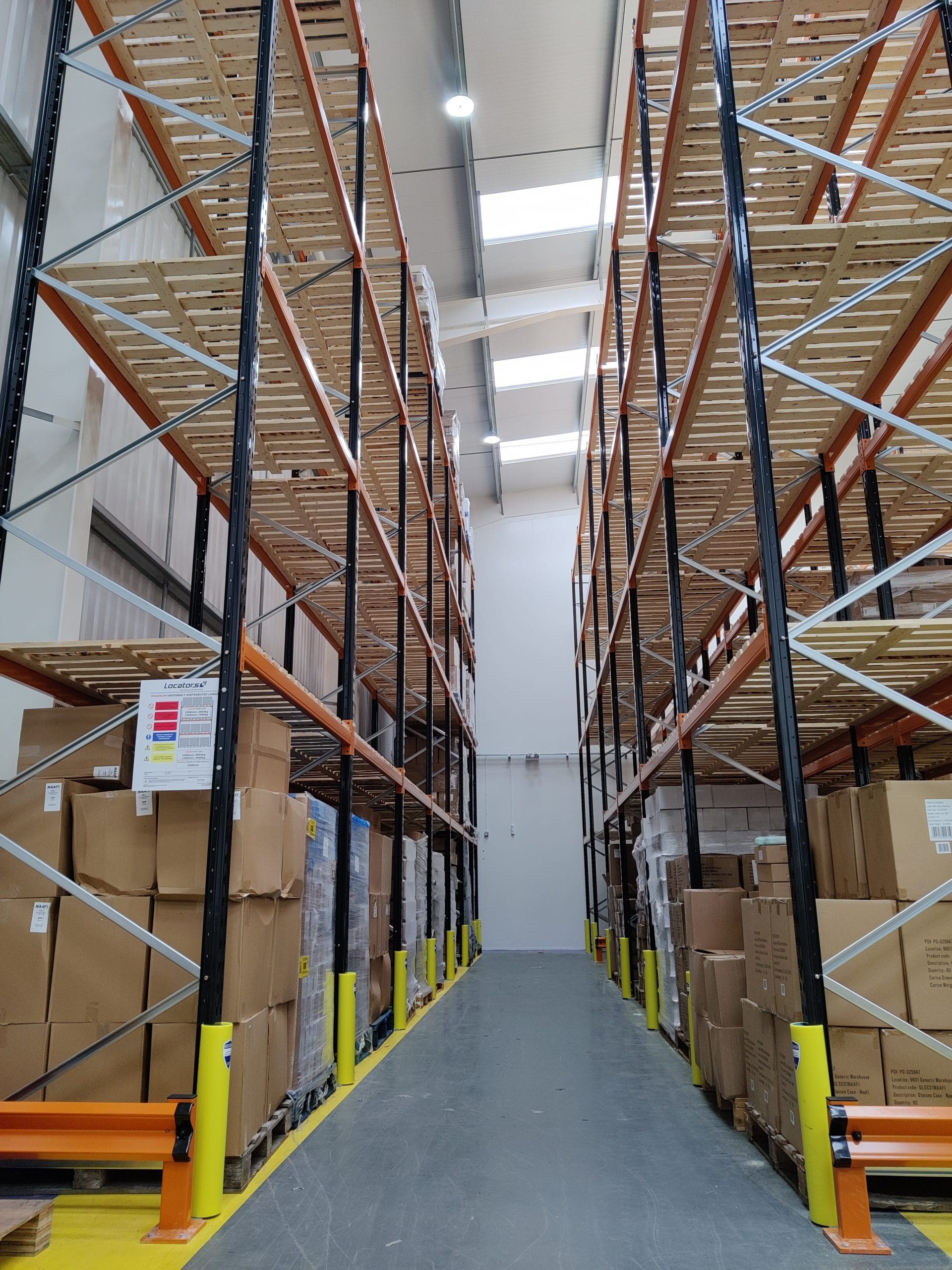 Long perspective view down a warehouse aisle with high storage racks.